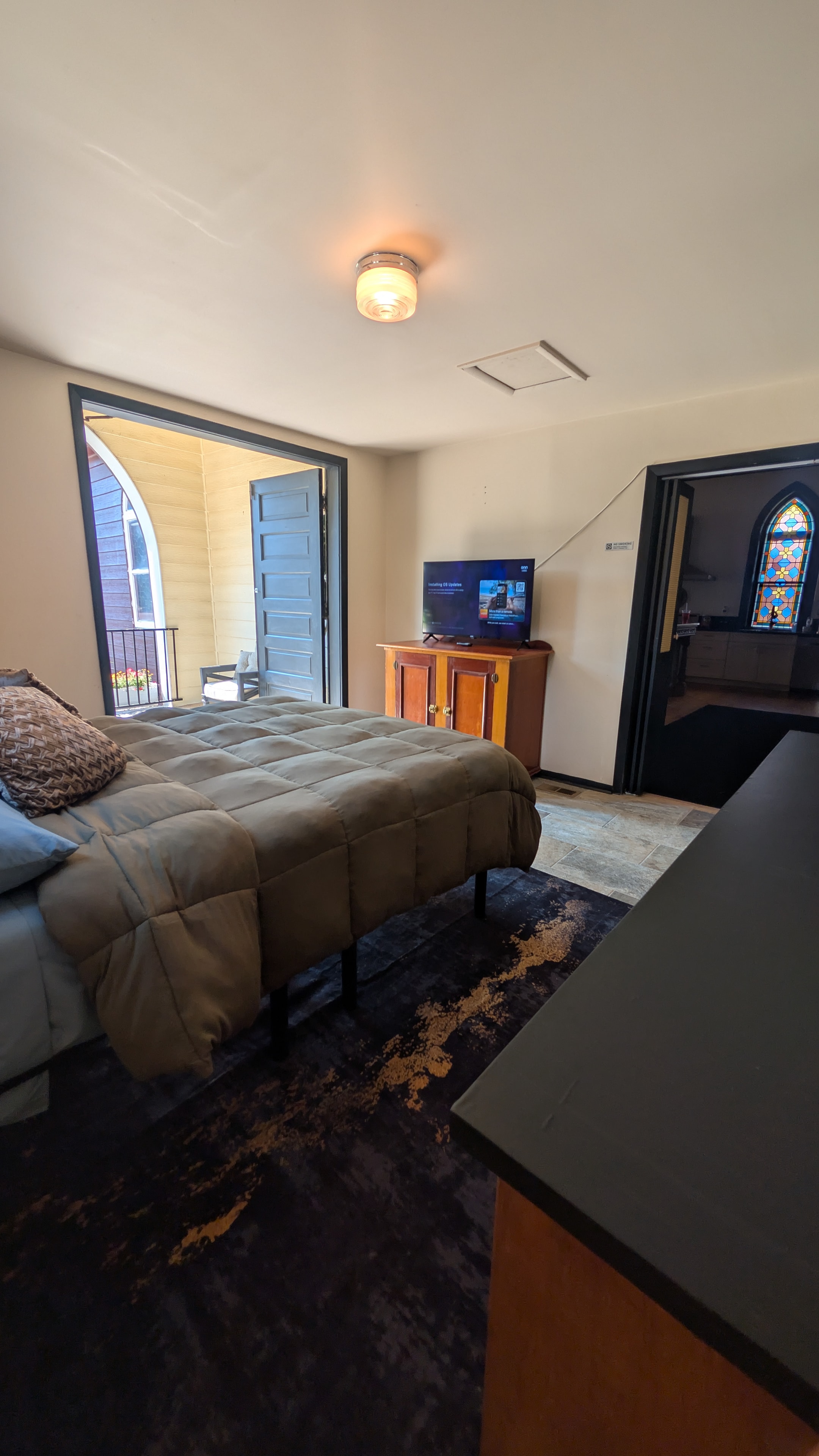 Chapel foyer with stained glass window, black wainscoting, and antique hutch