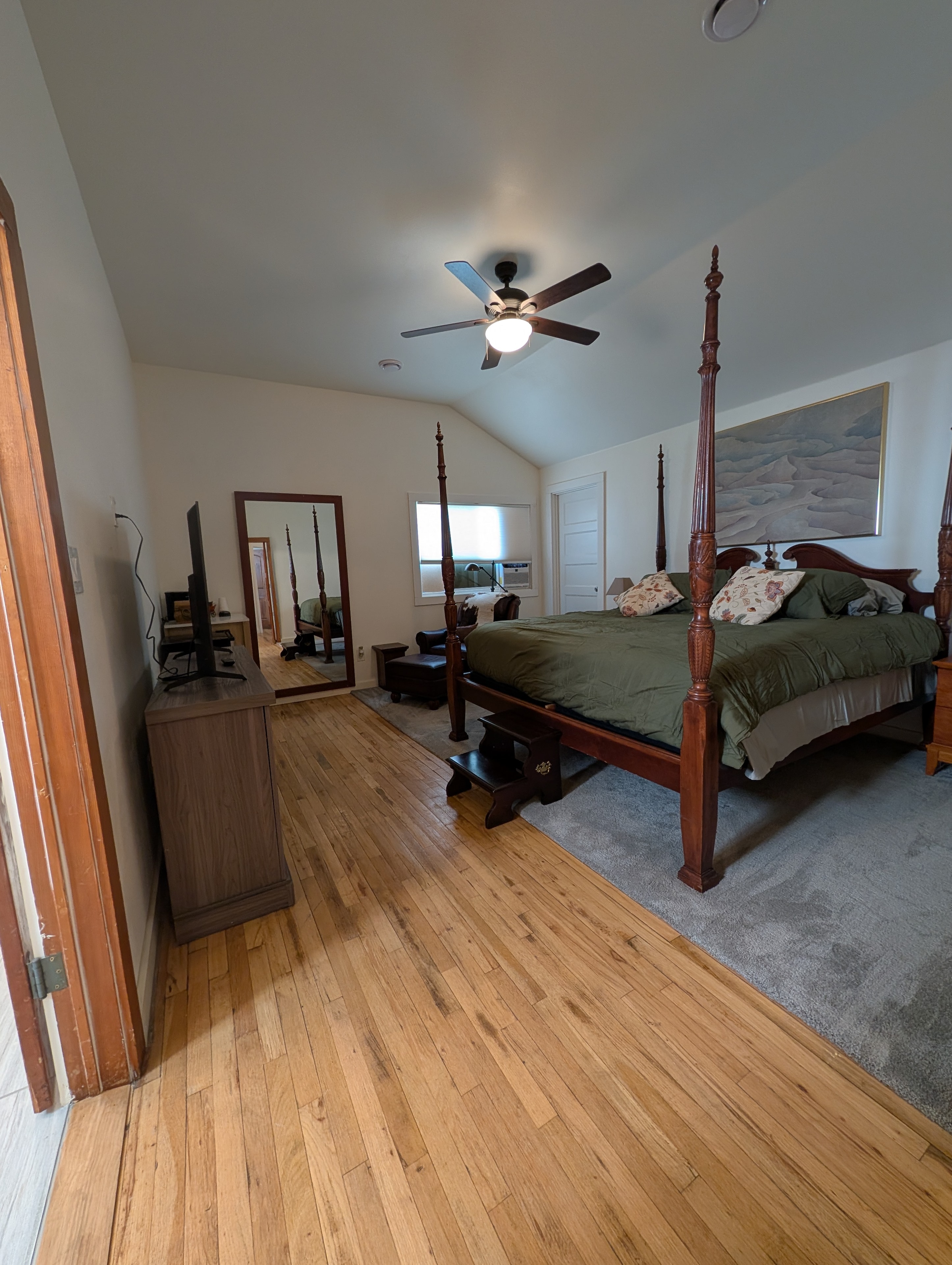 King master suite wide view with hardwood floors and ceiling fan